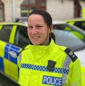 Female Police Officer Standing in front of Police car